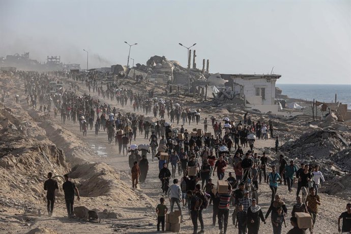 16 de junho de 2025, Territórios Palestinos, Cidade de Gaza: Palestinos carregam pacotes de alimentos, distribuídos pela "Gaza Humanitarian Relief Foundation", enquanto as pessoas lutam contra a fome em meio aos contínuos ataques israelenses à Cidade de G