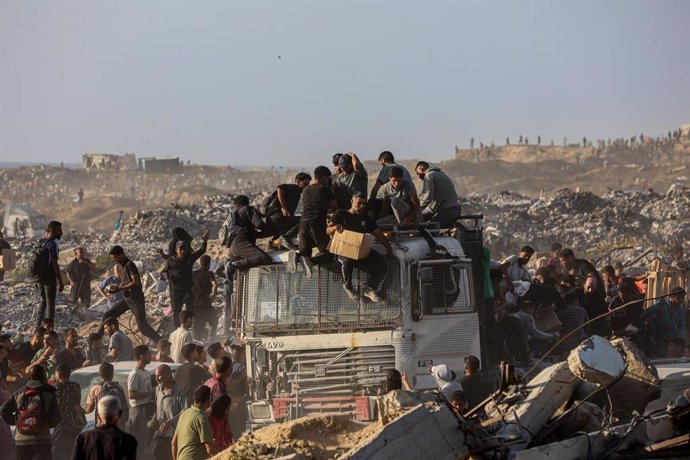 16 June 2025, Palestinian Territories, Gaza City: Palestinians carry food parcel, distributed by 'Gaza Humanitarian Relief Foundation' as people struggle with hunger amid the ongoing Israeli attacks on Gaza City. Photo: Omar Ashtawy/APA Images via ZUMA Pr