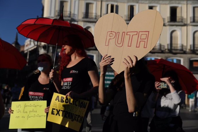 Archivo - Varias trabajadoras sexuales con carteles y paraguas rojos, durante una protesta contra la legislación en la prostitución, en la Puerta del Sol, a 22 de octubre de 2021, en Madrid (España).