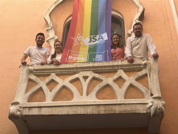 Miembros del PSOE y de Juventudes Socialistas de Jaén, junto a la bandera Lgtbi.