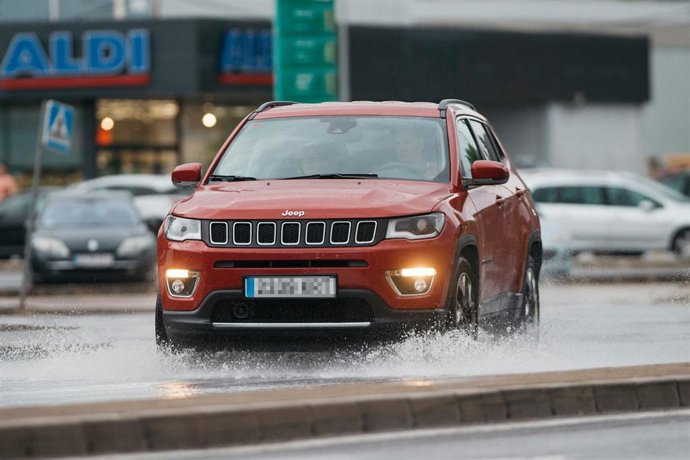 Archivo - Un coche circula bajo la lluvia en Castelló. Imagen de archivo.