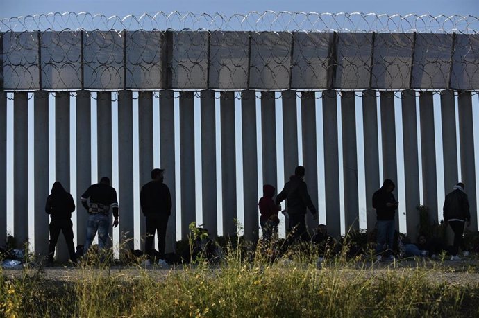 Archivo - Migrantes en el muro fronterizo de Tijuana-San Diego.