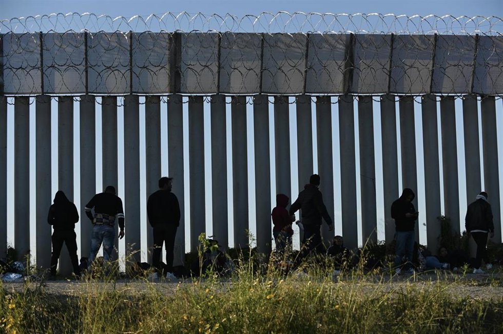 Archivo - Migrantes en el muro fronterizo de Tijuana-San Diego.