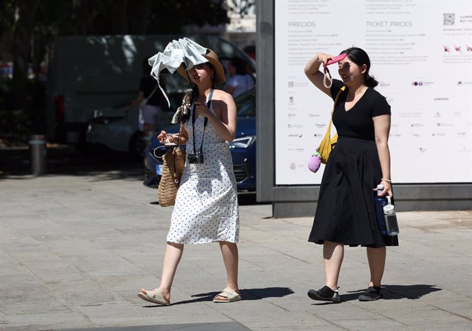 Archivo - Una mujer se refugia del calor con un paraguas durante una segunda ola de calor, a 23 de julio de 2024, en Madrid (España). Una segunda ola de calor llega hoy a la Península y afecta a gran parte del país hasta el jueves, con temperaturas que su