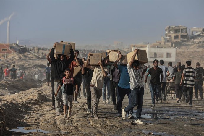 16 June 2025, Palestinian Territories, Gaza City: Palestinians carry food parcel, distributed by 'Gaza Humanitarian Relief Foundation' as people struggle with hunger amid the ongoing Israeli attacks on Gaza City. Photo: Omar Ashtawy/APA Images via ZUMA Pr