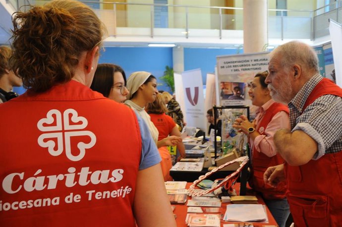 Archivo - Personal de Cáritas Diocesana de Tenerife atiende a un grupo de personas