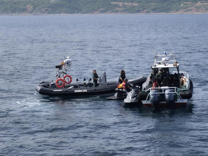 La Guardia Civil con las motos de agua que transportaban más de 120 kilos de hachís interceptadas.