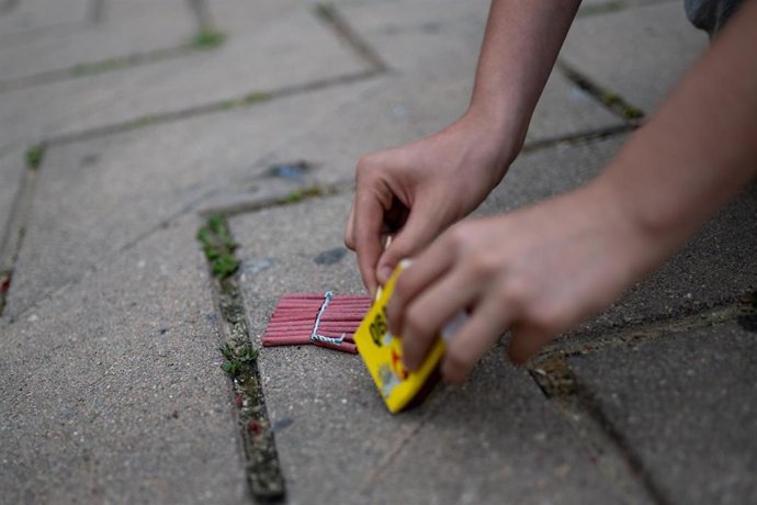Archivo - Una persona enciende petardos durante la verbena de San Juan, a 23 de junio de 2024, en Barcelona, Catalunya (España). La ciudad de Barcelona celebra Sant Joan, la noche más corta del año, una de las fiestas populares más arraigadas en Catalunya