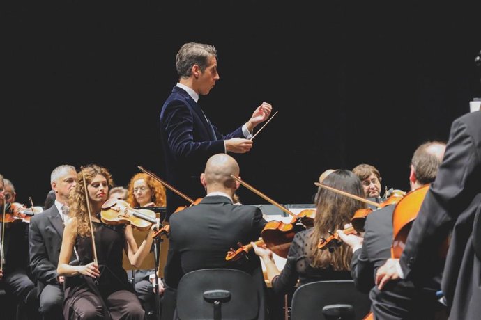 El director titular de la ROSS, Lucas Macías, dirige a los músicos, en foto de archivo.