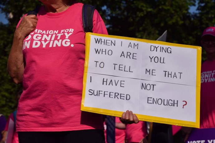 13 de junho de 2025, Londres, Reino Unido: Um manifestante segura um cartaz em apoio ao projeto de lei sobre morte assistida durante uma manifestação na Praça do Parlamento. O projeto de lei permitirá que adultos com doenças terminais recebam assistência 