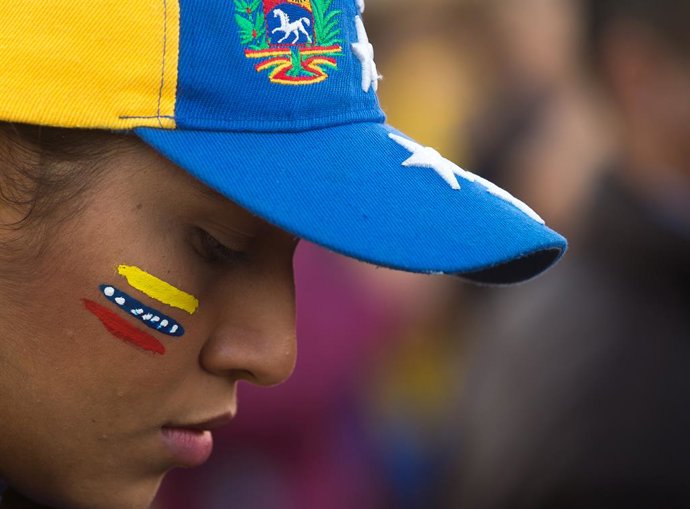 Archivo - Arquivo - 9 de janeiro de 2025, Málaga, Espanha: Uma venezuelana residente na Espanha com o rosto pintado com a cor da bandeira venezuelana é vista olhando para baixo enquanto participa de um protesto em apoio a Edmundo Gonzalez, na Plaza de la 
