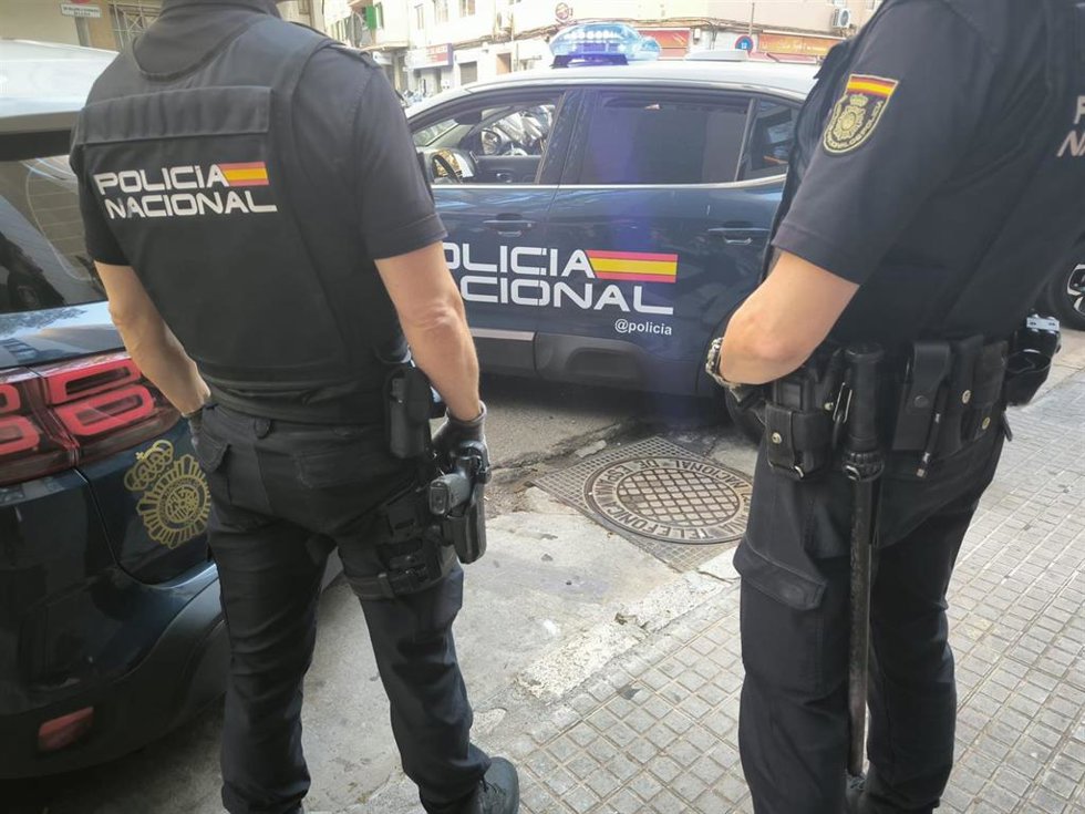 Agentes de la Policía Nacional frente a un vehículo policial. Recurso.