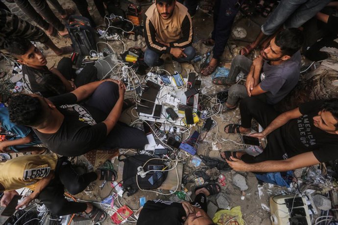 Archivo - FILED - 23 de outubro de 2023, Territórios Palestinos, Khan Yunis: Palestinos carregam seus celulares e baterias em uma estação de recarga da Sociedade do Crescente Vermelho Palestino. Os serviços de telecomunicação na Faixa de Gaza foram parcia