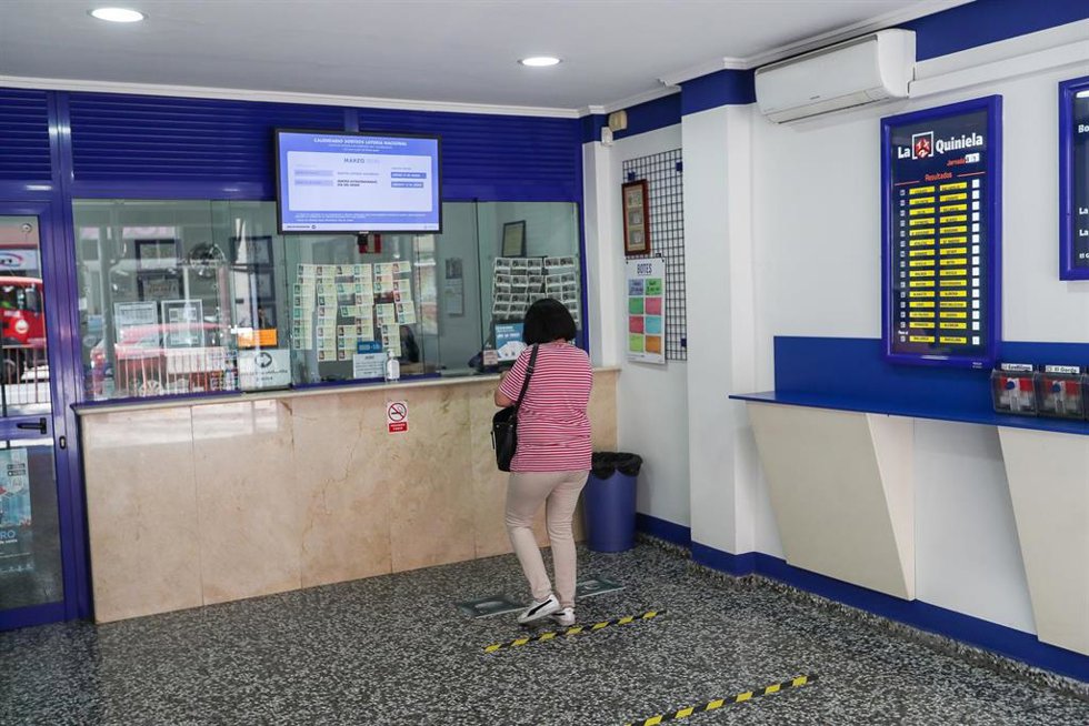 Archivo - Una mujer compra lotería en una Administración en Manises, Valencia, Comunidad Valencia (España), a 21 de mayo de 2020.
