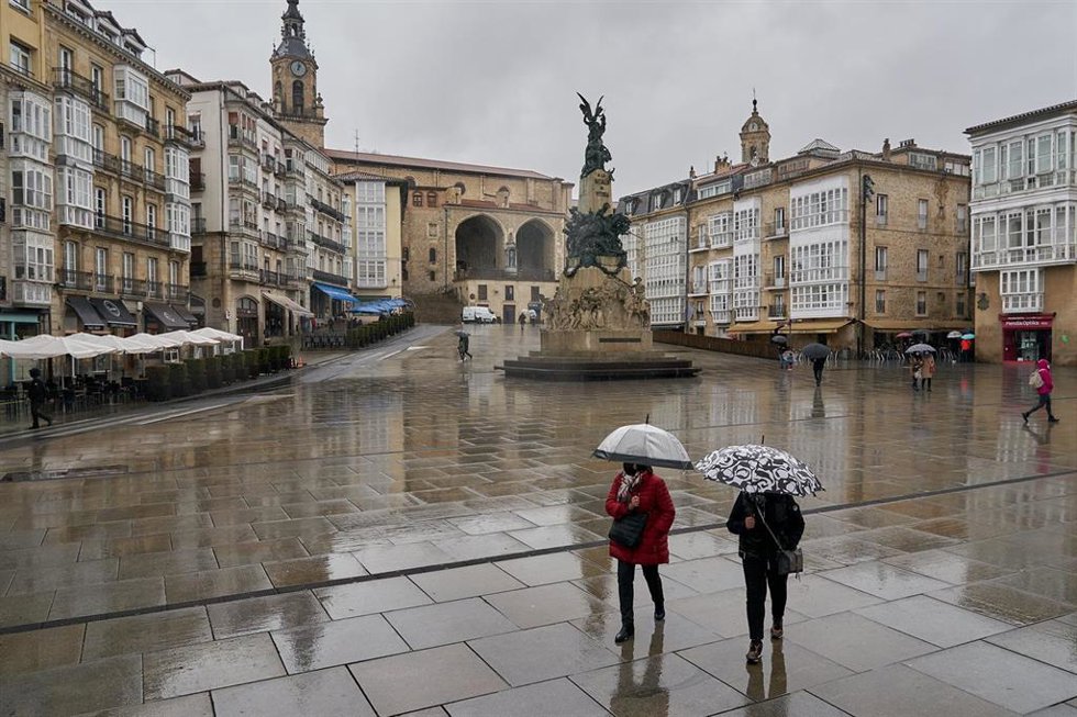 Archivo - Dos personas se refugian con un paraguas de la lluvia en Vitoria (archivo).