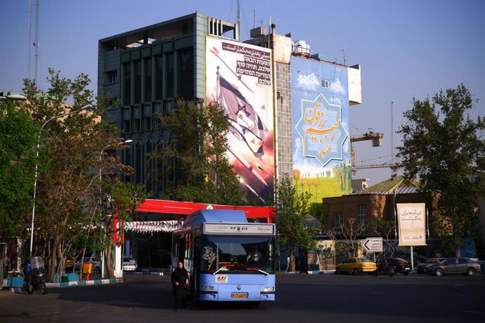 Archivo - Arquivo - 14 de abril de 2024, Irã, Teerã: Um ônibus para perto de um outdoor anti-Israel com uma frase em persa "O próximo tapa será mais forte" na Rua Palestina, no centro de Teerã. Israel, em 14 de abril, elogiou suas defesas aéreas diante de