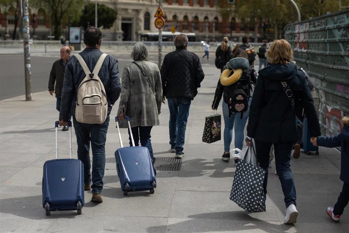 Archivo - Varias personas con maletas en la estación de tren Puerta de Atocha-Almudena Grandes.