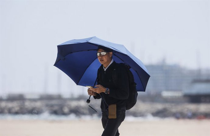 Archivo - Un hombre camina por la playa de la Malvarrosa, a 26 de abril de 2023, en Valencia, Comunidad Valenciana (España). Las temperaturas en la Comunitat Valenciana alcanzarán esta semana valores propios de verano, con máximas que podrían superar los 
