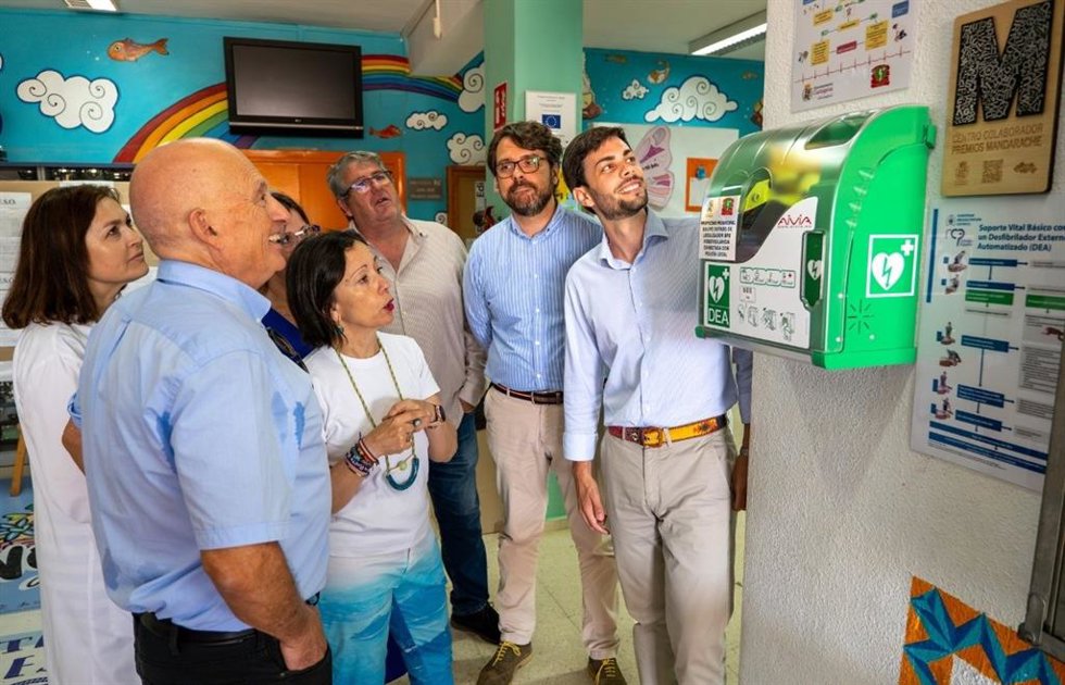Los concejales Álvaro Valdés e Ignacio Jáudenes junto al desfibrilador instalado en el IES San Isidoro de Los Dolores