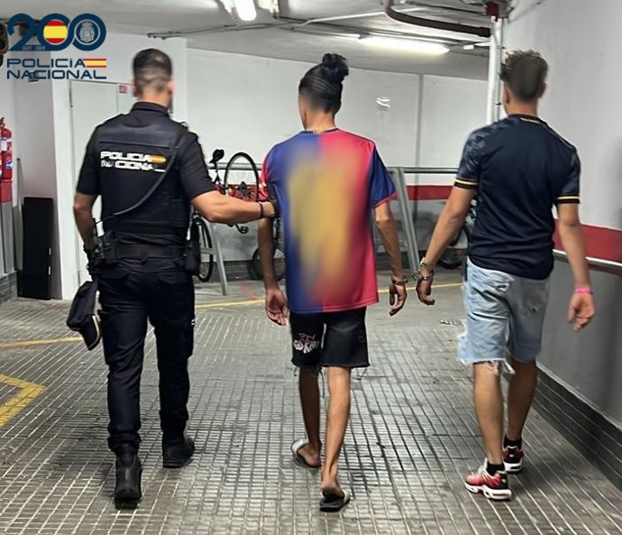 Agente de la Policía Nacional con los dos detenidos por intentar robar en una cafetería de Playa de Palma.