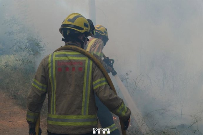 Bombers de la Generalitat trabajan en la extinción de un incendio próximo a la AP-7 en Báscara (Girona)
