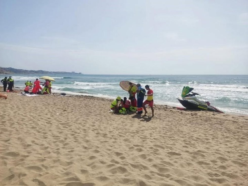 Socorristas atendiendo a dos personas con signos de ahogamiento  en una playa de Fuengirola