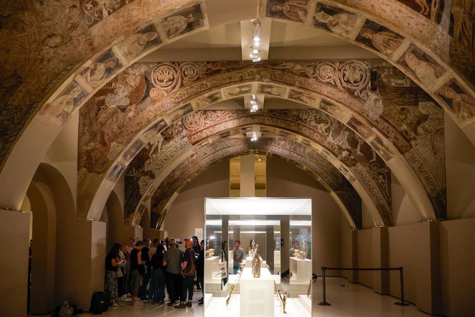 Varias personas observan las pinturas murales del Monasterio de Sijena expuestas en el Museu Nacional dArt de Catalunya (MNAC).