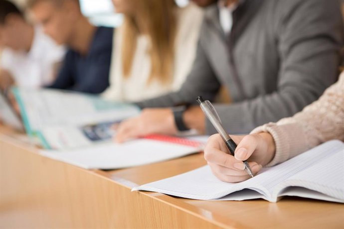 Preparing for exams. Cropped closeup of group of students sitting in a row writing during the lecture education studying campus college high school university teen people team together concept