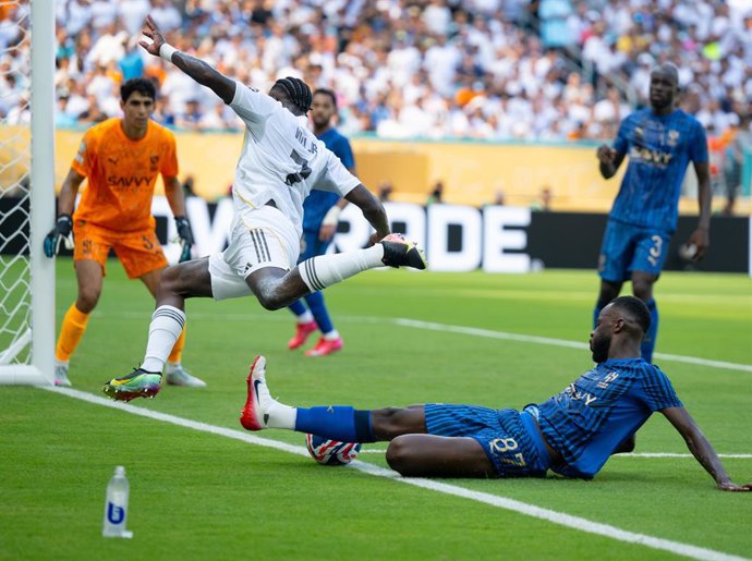 18 de junho de 2025, EUA, Miami: Vinicius Junior (C), do Real Madrid, e Hassan Altambakti (R), do Al-Hilal, disputam a bola durante a partida de futebol do Grupo H da Copa do Mundo de Clubes da FIFA entre Real Madrid e Al-Hilal no Hard Rock Stadium. Foto: