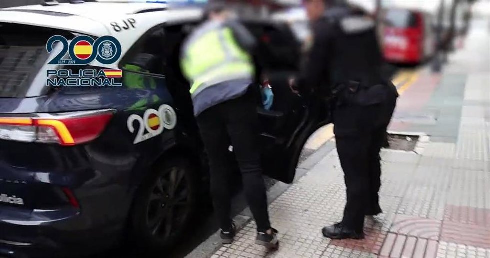 Agentes de la Policía Nacional instroducen en un coche policial a un detenido acusado de explotación sexual