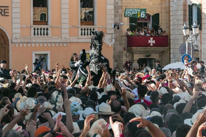 Decenas de personas durante el Caragol des Born en la Plaça Es Born en Ciutadella durante las Fiestas de Sant Joan, a 23 de junio de 2025, en Menorca