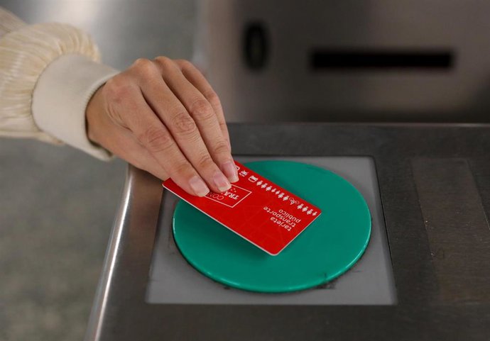 Archivo - Una persona pasa su título de transporte para acceder a Metro