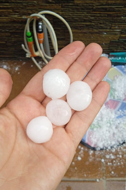 Una persona muestra el tamaño de las “bolas de granizo”, a 11 de junio de 2025, en Navalcarnero, Madrid (España). La Agencia Estatal de Meteorología (Aemet) ha elevado el aviso amarillo emitido para la jornada de este miércoles a nivel naranja, ante la pr