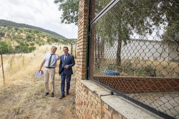Salvador Fuentes (izda.) comprueba, junto a Javier Murillo, la situación del muro que perimetra el CEIP Miguel de Cervantes de Villanueva del Rey.