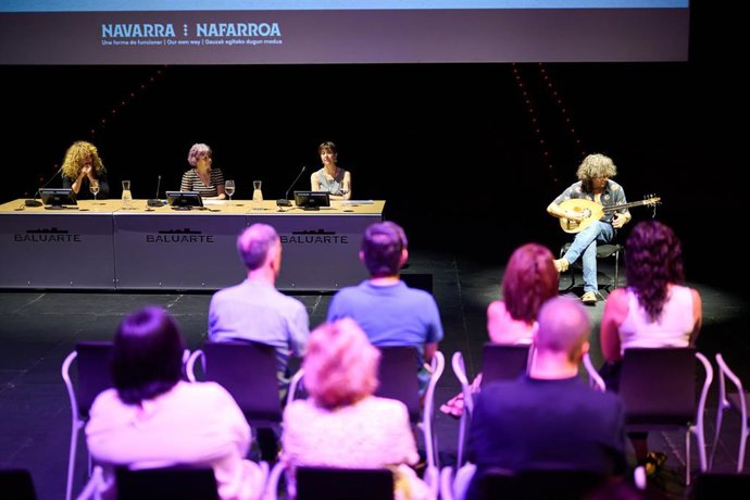 De izquierda a derecha, la directora artística, Raquel Andueza; la consejera Esnaola;  y la jefa de Sección de Programas Artísticos y Difusión, Marisol Martínez. A la derecha, interpretación del guitarrista, Enrike Solinis.