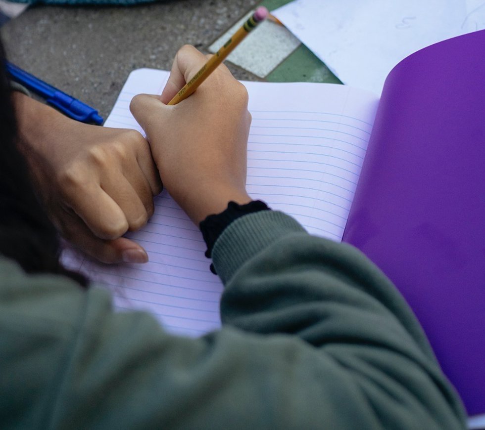Archivo - Estudiante escribiendo en clase.