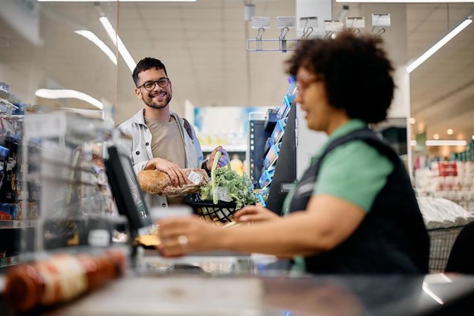 Hombre pasando por la caja de un supermercado.