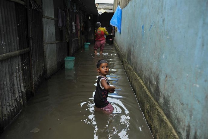 Archivo - Un niño durante las inundaciones en Bangladesh en 2024.