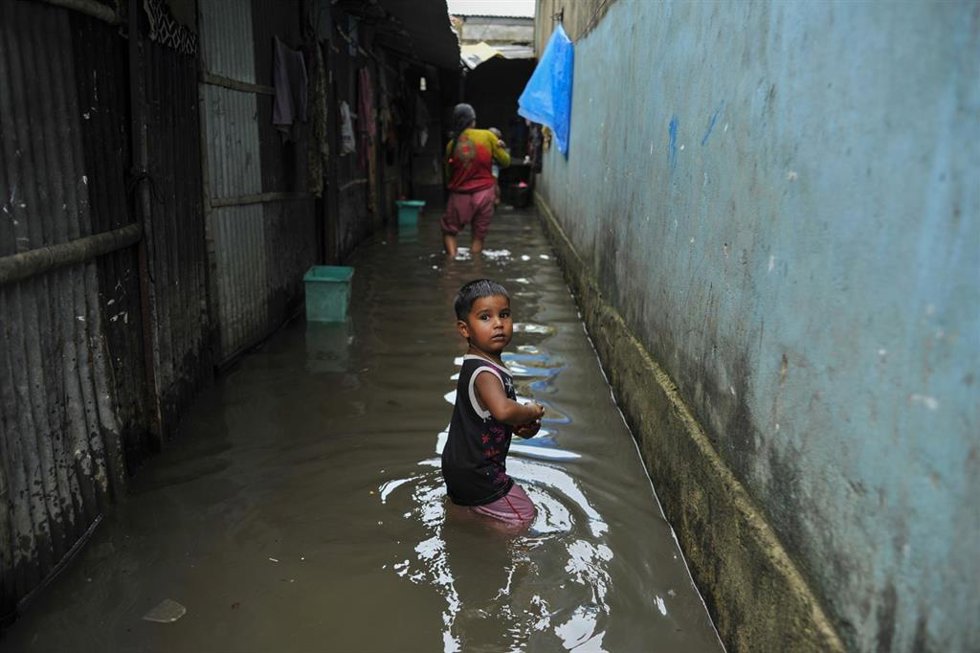 Archivo - Un niño durante las inundaciones en Bangladesh en 2024.