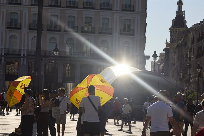 Varias personas pasean por la calle, a 16 de junio de 2025, en Madrid (España). La Agencia Estatal de Meteorología (AEMET) activa el aviso amarillo en Madrid este lunes y martes por temperaturas que superarán los 36 grados en varias zonas de la región. El