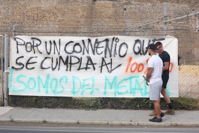 Trabajadores del metal de Cádiz durante la huelga de este martes, segundo día de huelga indefinida, frente a una pancarta que reclama un convenio justo.