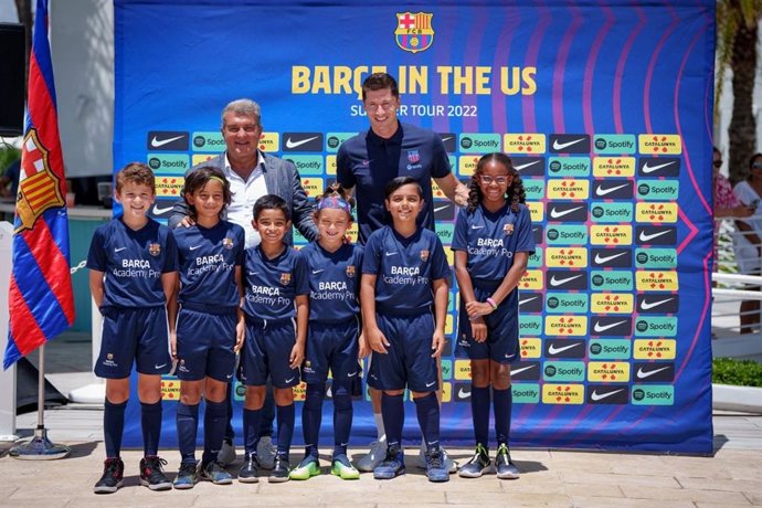Archivo - Polish footballer Robert Lewandowski stands next to Barcelona President Joan Laporta as they pose for a photo with children from the Barca Academy Pro during a press conference to present Lewandowski as the new player for the team. 