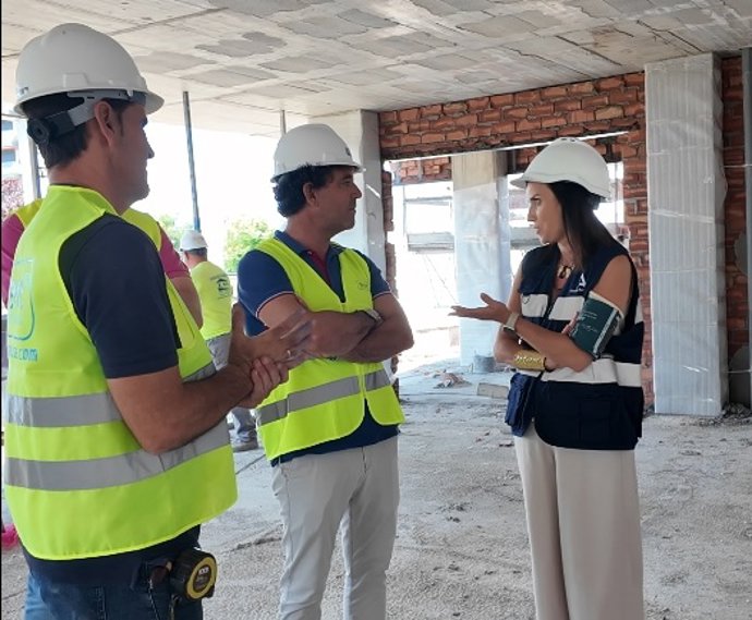 La delegada de Empleo (centro) habla con el responsable de Serrot durante la visita a la obra.