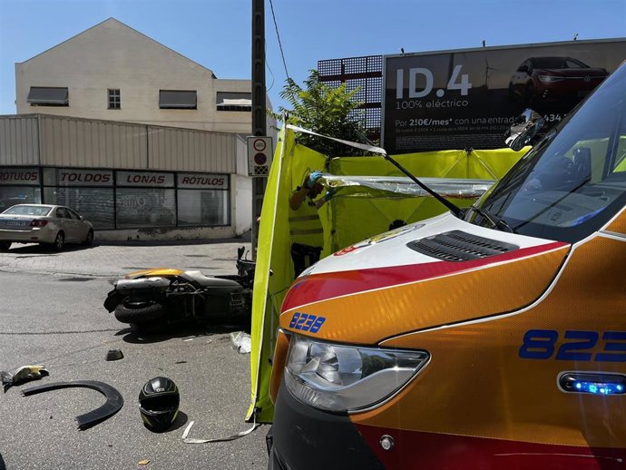 Una ambulancia de Samur-Protección Civil en el lugar de un accidente entre una moto y un vehículo en un cruce en Villa de Vallecas.