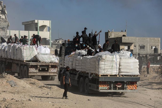June 25, 2025, Gaza City, Gaza Strip, Palestinian Territory: Palestinians from clans hold melee weapons to secure an aid truck in Beit Lahia, in the northern Gaza Strip, June 25, 2025