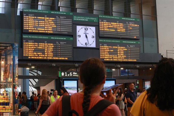 Archivo - Viajeros en la estación de Santa Justa esperan a coger sus trenes