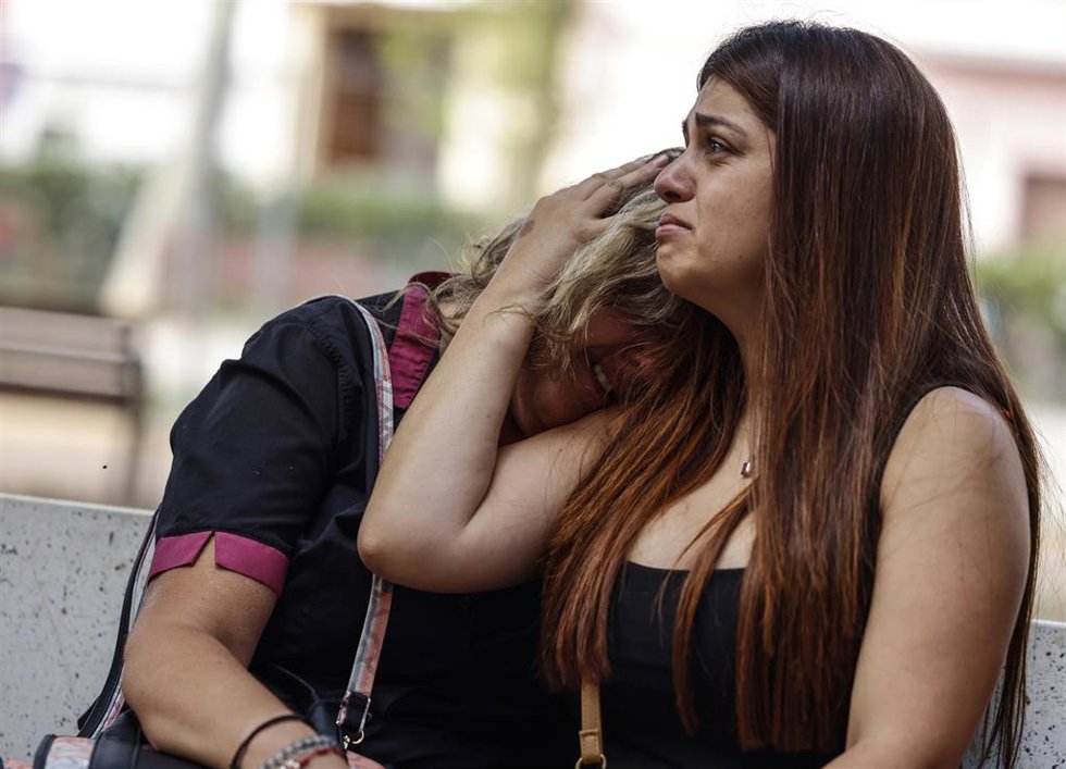 Dos personas se abrazan en el lugar donde han ocurrido los hechos, a 25 de junio de 2025, en Algemesí, Valencia