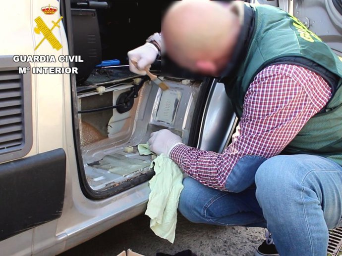 Agente de Tráfico de la Guardia Civil en investigación del número de bastidor de un vehículo