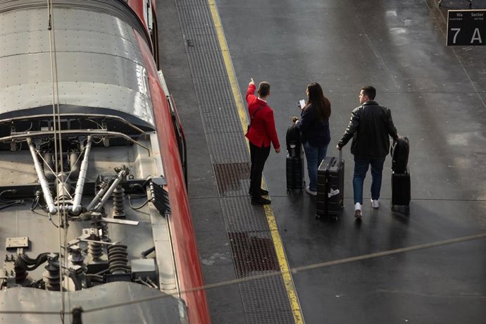 Archivo - Un trabajador de Renfe junto a dos personas en uno de los andenes de la estación de Atocha-Almudena Grandes, a 26 de marzo de 2025, en Madrid (España). 