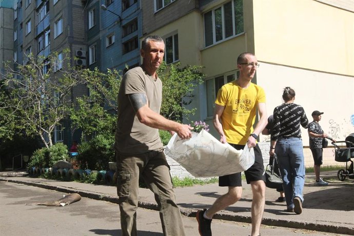 Archivo - Hombres retiran escombros de un bloque de apartamentos alcanzado por un dron ruso en Kamianske, región de Dnipropetrovsk.